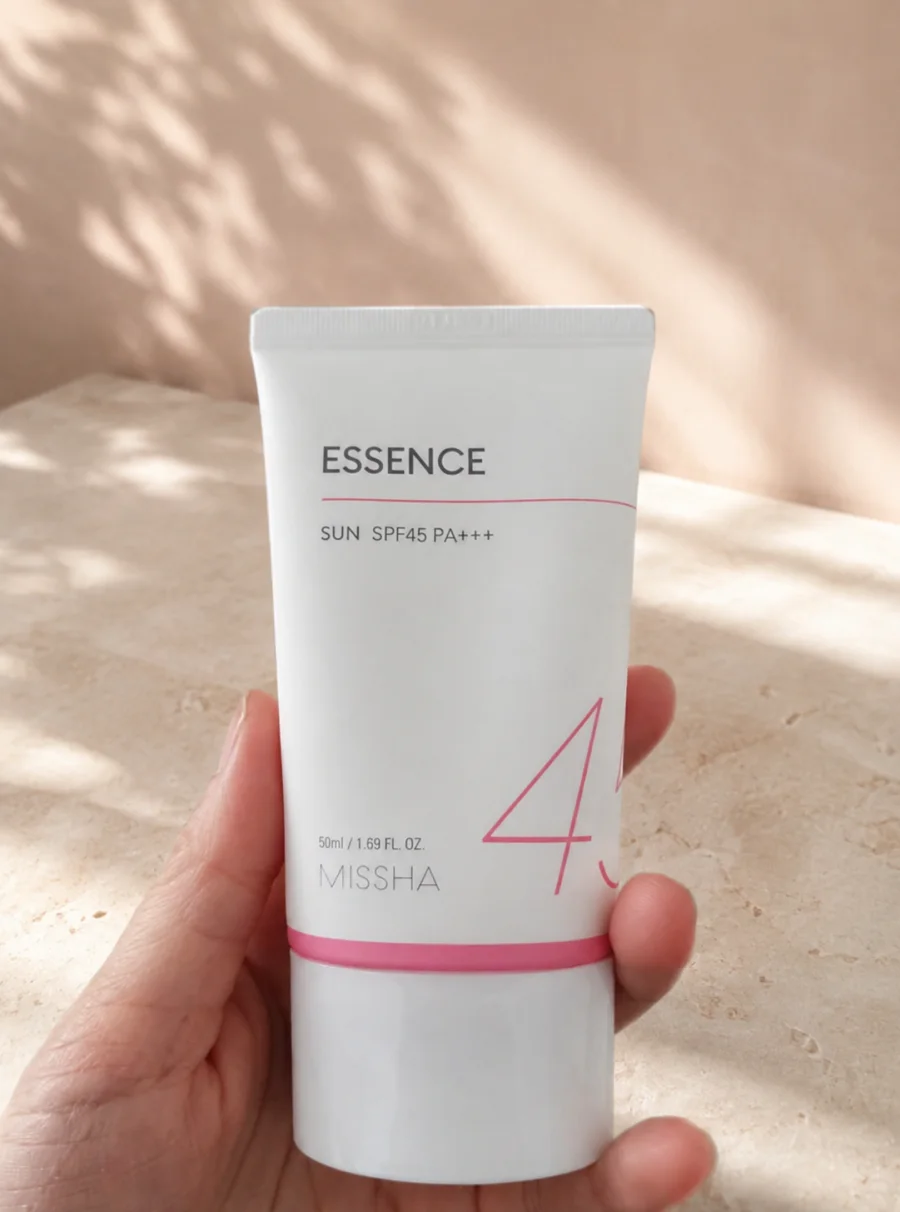 Tube de la crème solaire MISSHA Essence Sun SPF45 PA+++ tenu en main