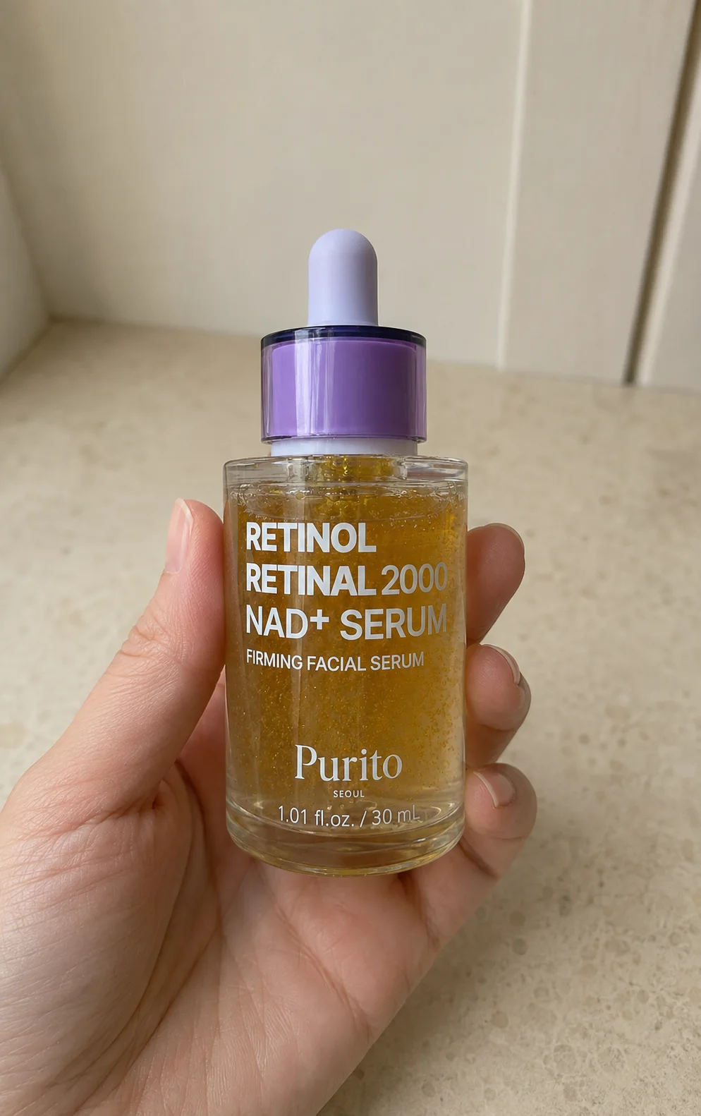 Flacon Purito Seoul Retinol Retinal 2000 NAD+ Serum tenu en main