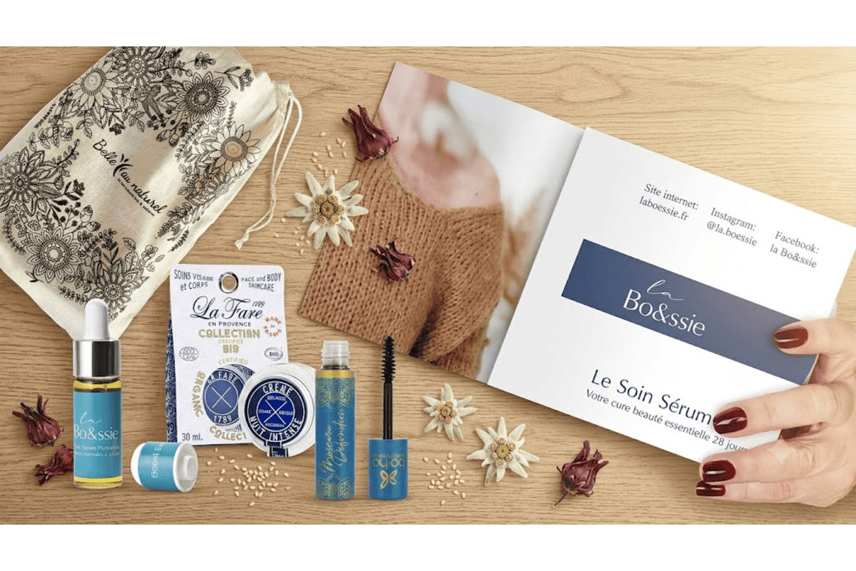 Belle au Naturel coffret Essentiels 40 ans présentation produits pochon coton bio sigle BAN sérum La Bo&ssie booster d'éclat pipette doseuse fioleverre Crème de Nuit La Fare en Provence pot verre fleurs séchées edelweiss livret soin sérum sur table bois clair