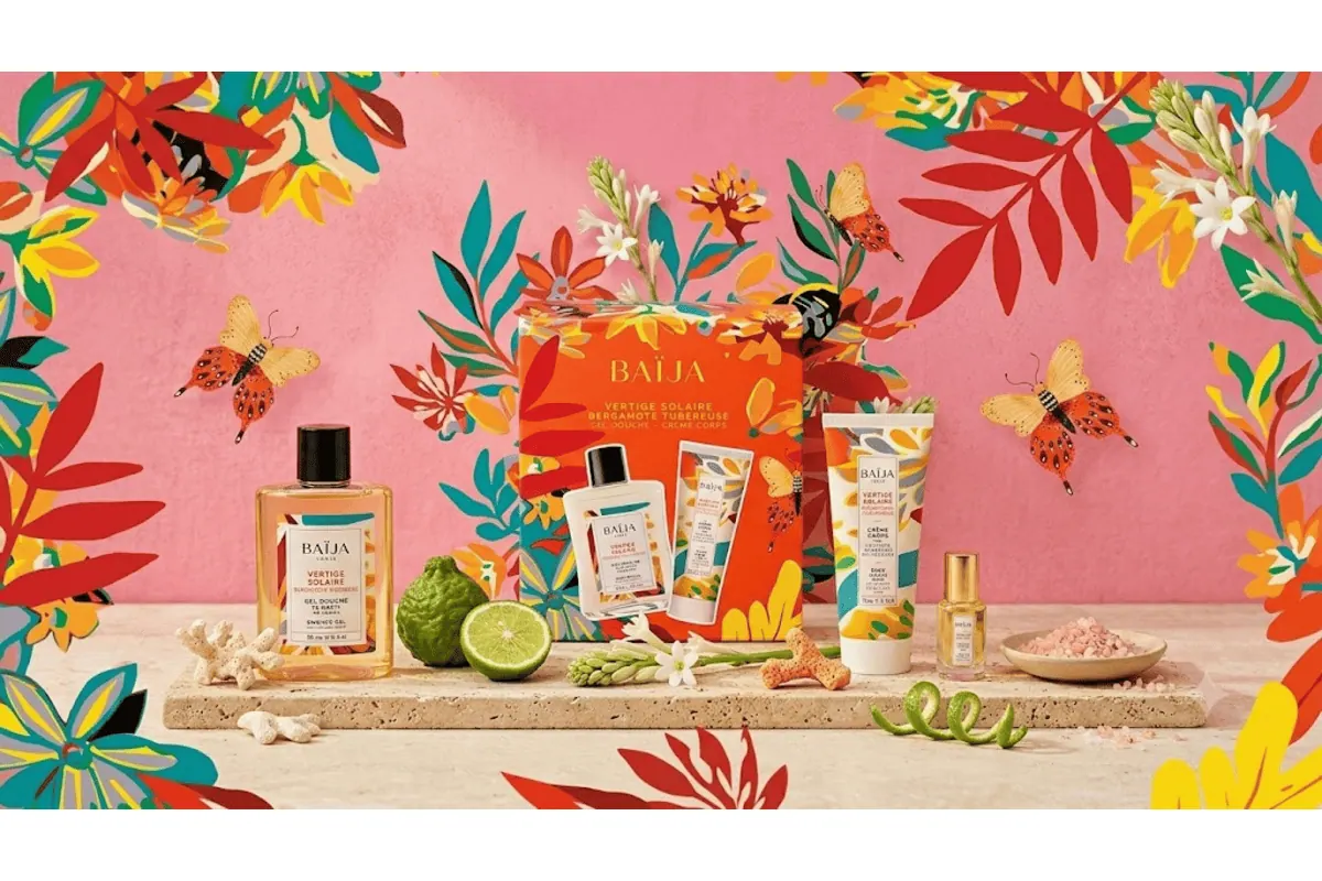 Coffret Baïja Vertige Solaire avec gel douche et crème corps Bergamote Tubéreuse sur plateau de pierre avec bergamote, citron vert, papillons et fleurs de tubéreuse sur fond rose tropical illustré