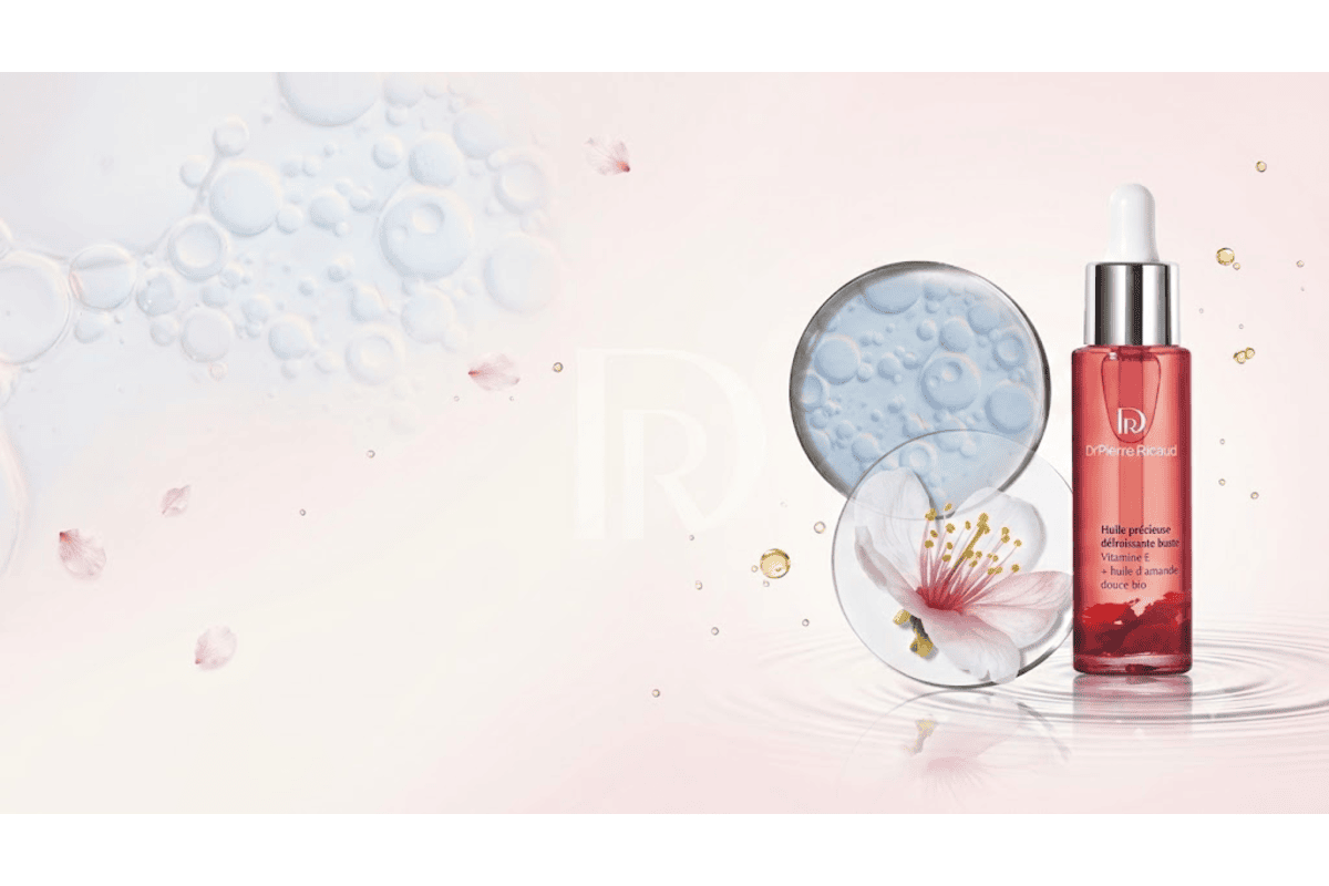 Dr Pierre Ricaud huile précieuse buste flacon rouge bulles d'huile gouttes fleur de cerisier bio actifs vitamine E amande douce pétales rose texture légère soyeuse fabriquée en France
