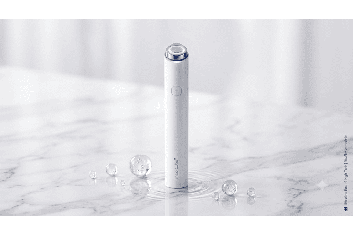 medicube AGE-R Booster Pro Mini blanc appareil soin visage LED bleue allumée posé sur marbre avec bulles d'eau cristallines rituel beauté high-tech révèle votre éclat K-beauty Corée
