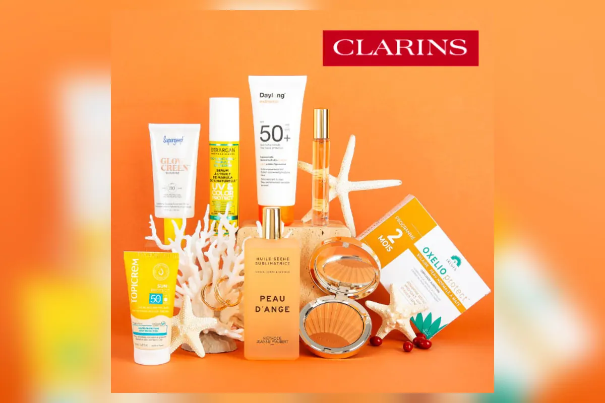 Box Beauté Solaire Marie Claire avec 8 produits et 1 accessoire sur fond orange