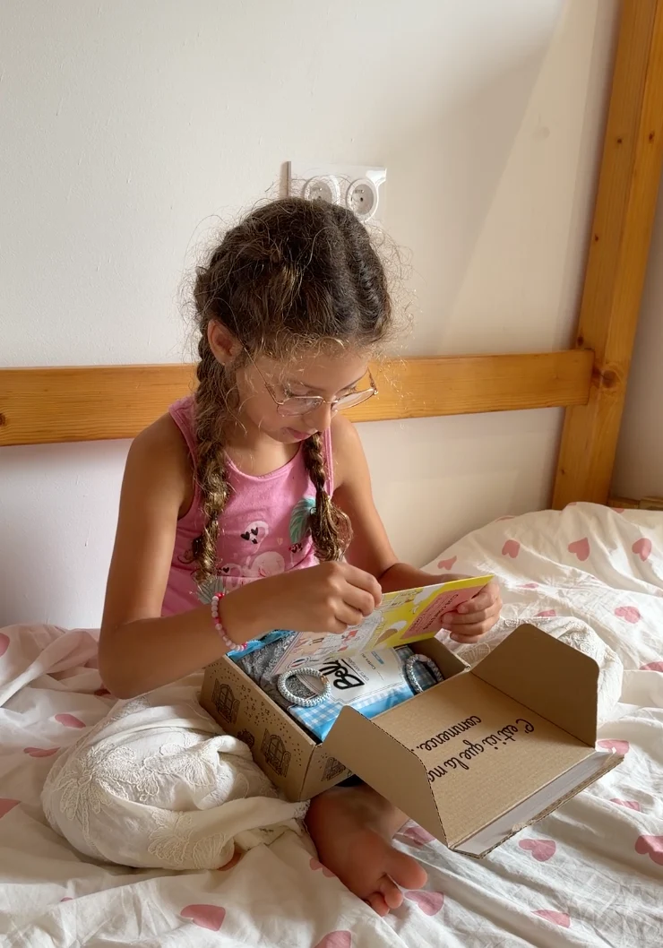 Une enfant découvre le contenu d’une box Mademoiselle Confettis