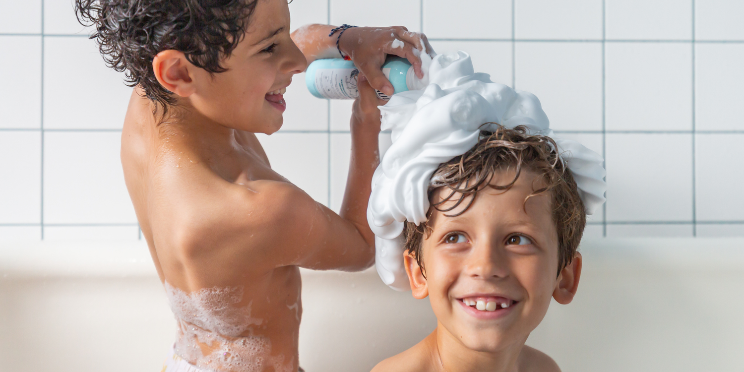 Deux enfants utilisant la mousse Ma Chantilly Lavante OUATE dans leur bain