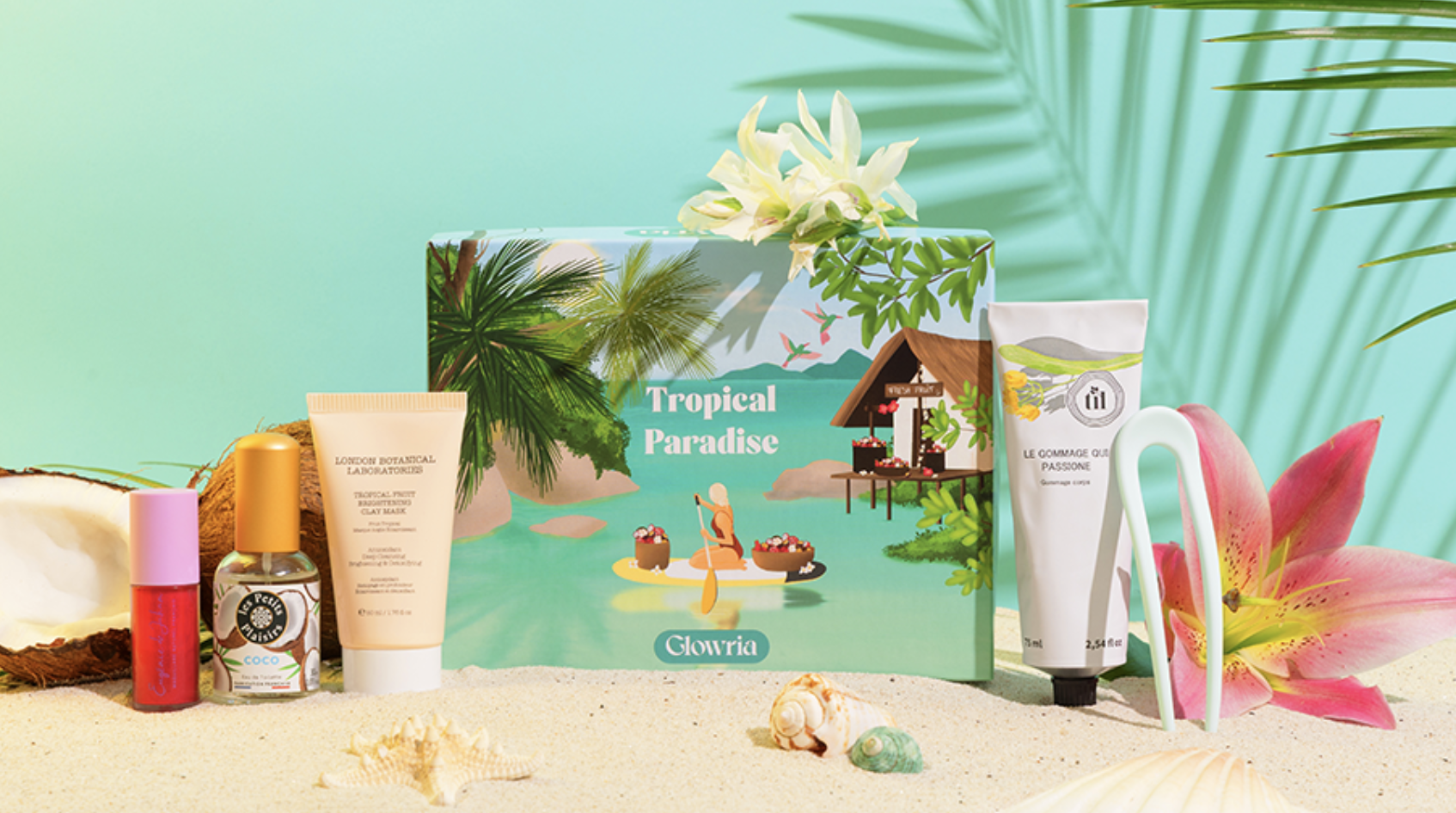 Box Glowria Tropical Paradise et ses cinq produits beauté officiels sur un décor de plage tropicale