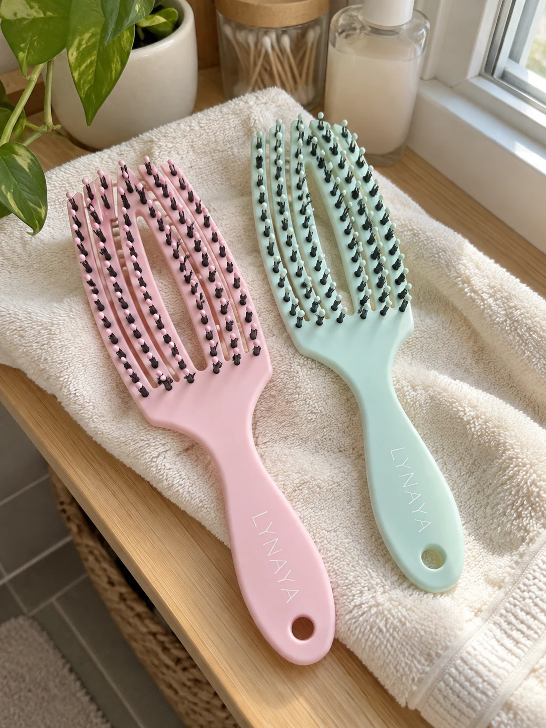 Brosses LYNAYA Rose Blush et Vert d’eau sur une serviette crème