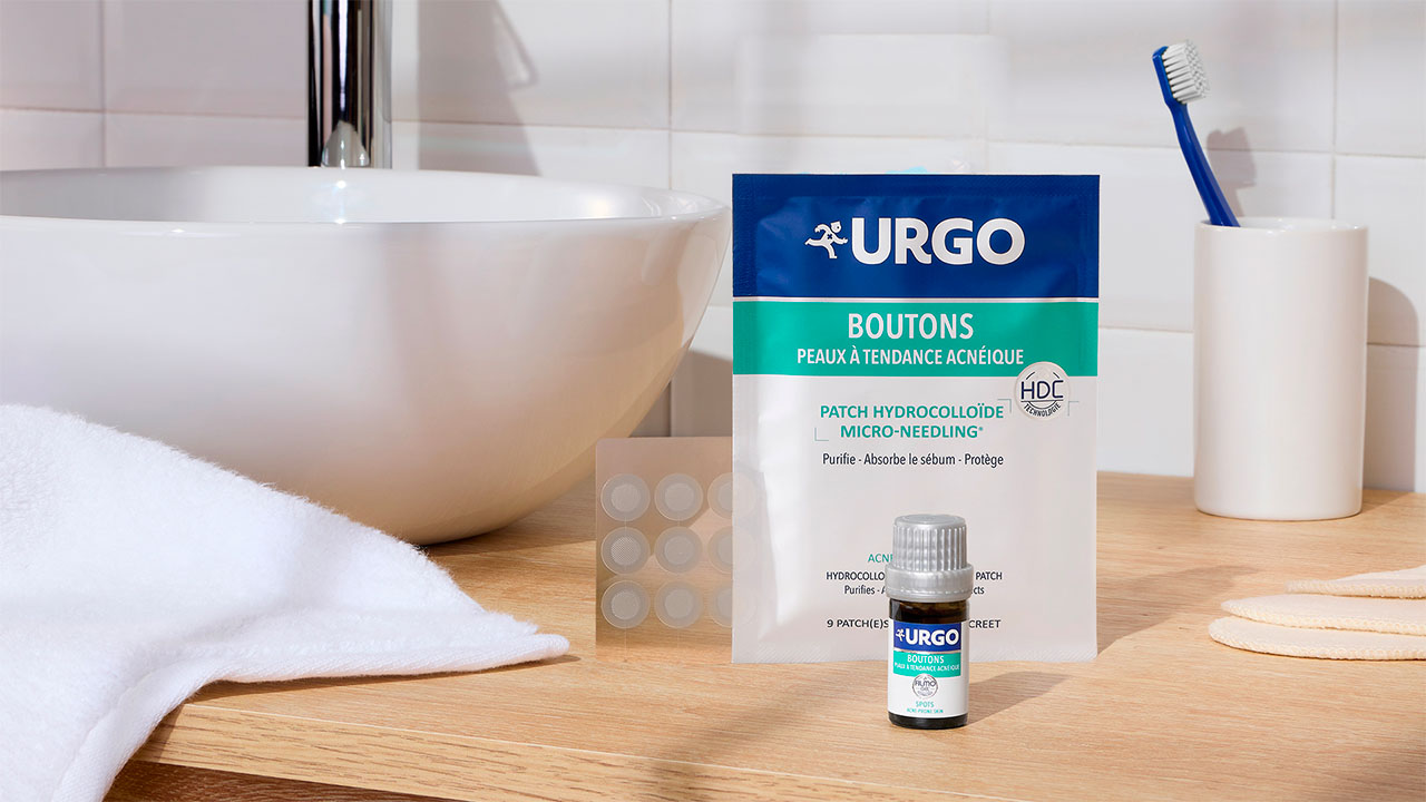 Patchs hydrocolloïdes et Filmogel Boutons URGO présentés sur un meuble de salle de bain
