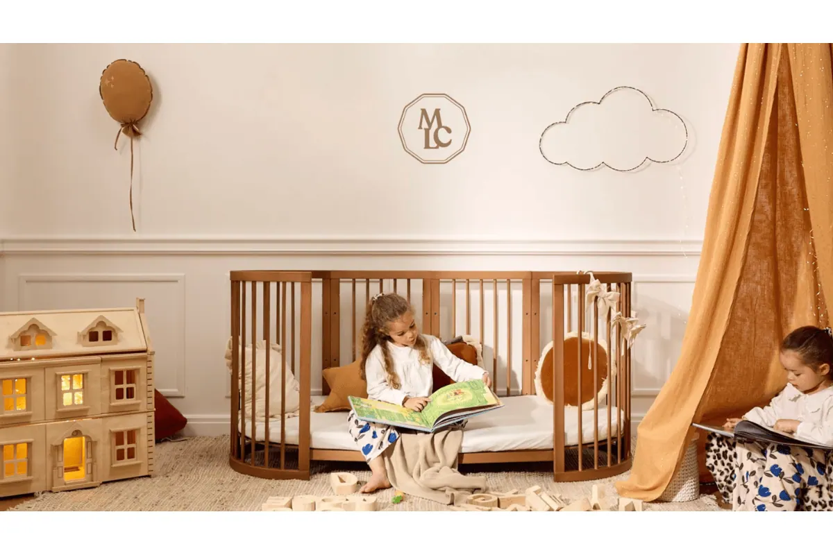 Mon Lit Cabane berceau évolutif ovale 9-en-1 bois massif coloris noisette petite fille assise lisant test gratuit Mamadvisor 500 euros